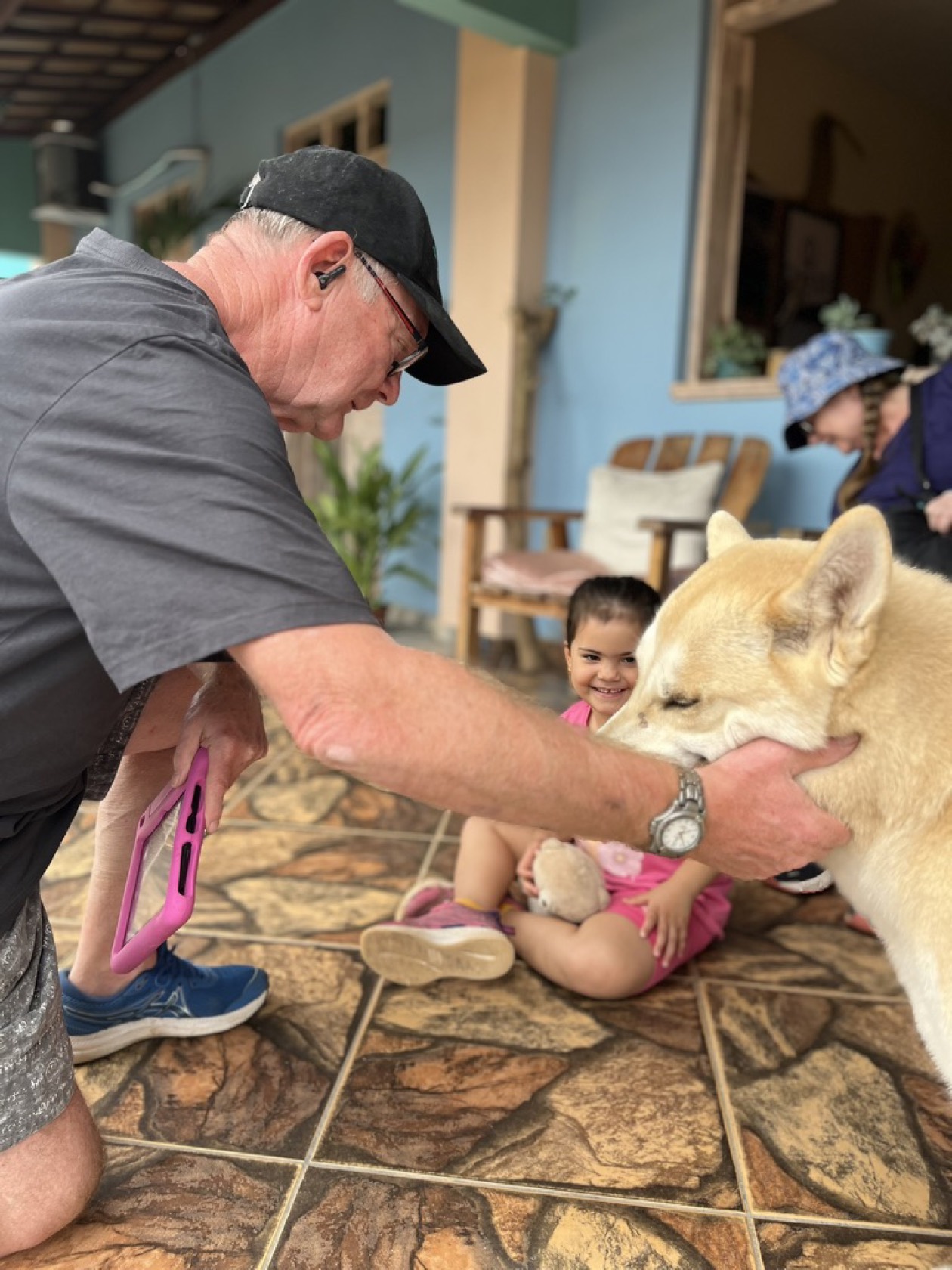 Família com criança fazendo carinho no cachorro na recepção